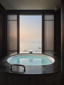a bath tub with a view of the ocean at Ananti at Busan Cove in Busan