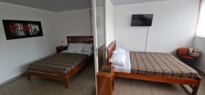 ラ・ベガにあるHotel Finca los Cristalesのベッド2台と鏡のある寝室 +20枚の写真