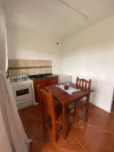 a kitchen with a table and chairs and a stove at Cabañas Inti Huasi in Tafí del Valle