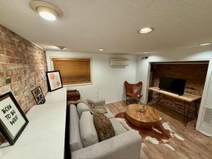 a living room with a couch and a television at Charming Marmalade Flat in Downtown Salt Lake City in Salt Lake City