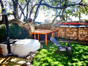 a table and a chair under a tree at SURFtoLIVE House in Somo