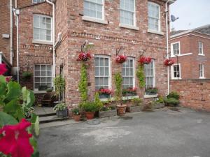 a brick building with potted plants on the windows at Ba Ba Guest House in Chester