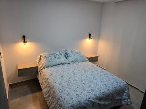 a bedroom with a bed and two lights on the wall at Apto fresco cómodo cerca a Foscal y Cañaveral in Floridablanca