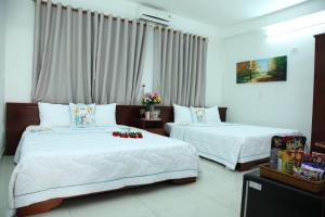 twee bedden in een hotelkamer met bloemen erop bij An Bình Tài Hotel in Da Nang +40 foto's