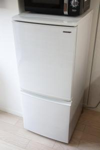a white refrigerator with a microwave on top of it at Isole le Olena 201 in Naha