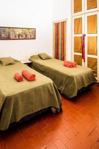 two beds in a room with red pillows on them at Lo de Sara. Casa pequeña al pie del cerro in Yerba Buena