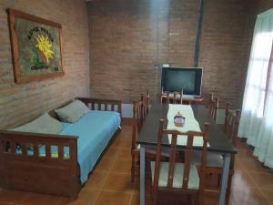 a room with a table and a bed and a television at Cabañas Inti Huasi in Tafí del Valle