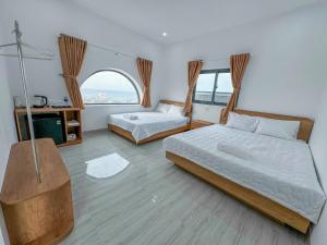 a bedroom with two beds and a window at D&T House in Cù Lao Thu