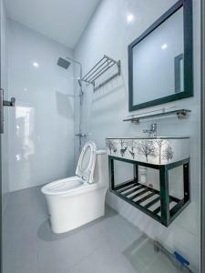 un bagno con un water, un lavandino e uno specchio di D&T House a Cù Lao Thu