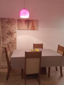 a dining room with a table and a pink light at Recanto família rocha in Ribeirão das Neves