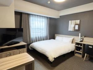 una camera da letto con un letto e una TV a schermo piatto di Hotel Route Inn Noda -Kokudo 16 Gouzoi- a Noda