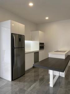 a kitchen with a stainless steel refrigerator and a table at Optimus Rentals in Rudi Kappel