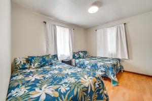 a bedroom with two beds and two windows at 2 Mi to Hawaii Volcanoes Natl Park Tranquil Home in Volcano