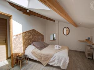 una camera da letto con un letto grande in una mansarda di Séjour paisible en gîte de charme avec spa en campagne - FR-1-496-334 a Saint-Julien-Molin-Molette