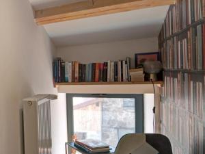 una stanza con finestra e libreria con libri di Séjour paisible en gîte de charme avec spa en campagne - FR-1-496-334 a Saint-Julien-Molin-Molette