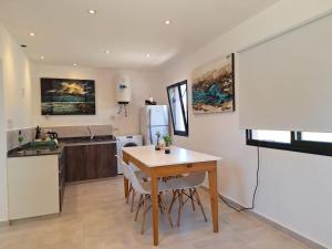 a kitchen with a table and a kitchen with a refrigerator at Pintó-apart in Cafayate +24 photos