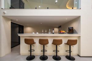 une cuisine avec un bar avec trois tabourets dans l'établissement Dali Shuanglang Haiyu Sea View B&B (Double Corridor shop), à Dali