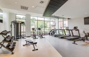 a gym with several treadmills and elliptical machines at Upscale 4BR Penthouse with Gym & Parking near MGH & TUFTS in Boston