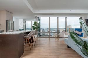 a kitchen and living room with a view of a city at Upscale 4BR Penthouse with Gym & Parking near MGH & TUFTS in Boston