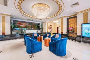 蘭州市にあるGrand Soluxe Hotel Gansuの青い椅子と大きなシャンデリアが備わるロビー