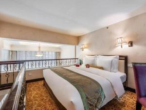 蘭州市にあるGrand Soluxe Hotel Gansuの大きなベッドとバルコニーがあるホテルの部屋