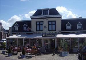 a hotel with tables and chairs in front of a building at Hotel De Vrouwe van Stavoren in Stavoren