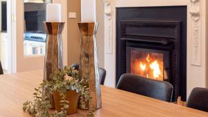 a table with two candles and a fireplace at Secret Garden in Bowral
