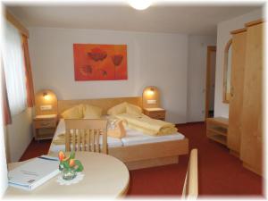 Kleines Zimmer mit einem Bett und einem Tisch in der Unterkunft Gästehaus Edelweiss in Sautens