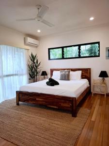 Un dormitorio con una cama grande con una ventana grande. en The Nest!, en Cannonvale