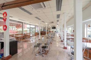 a cafeteria with tables and chairs and windows at OYO 1089 Baan Boran in Bangkok