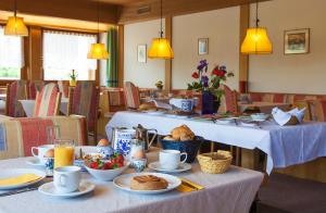 una sala da pranzo con due tavoli con sopra del cibo di Pension an der Mayenburg a Vollan