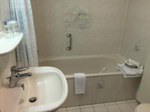 a bathroom with a sink and a bath tub at Hotel De Vrouwe van Stavoren in Stavoren