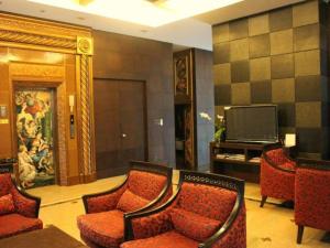 a lobby with chairs and a television in a building at Maleewana Hotel & Resort in Bang Yai