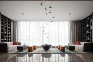 un salon avec deux canapés et une grande fenêtre dans l'établissement Atour Hotel Guangzhou Baiyun New Town Jiangxia Metro Station, à Canton