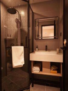a bathroom with a sink and a shower with a mirror at GreenTree Inn Datong YundinGYAyuan Express Hotel in Datong +251 photos