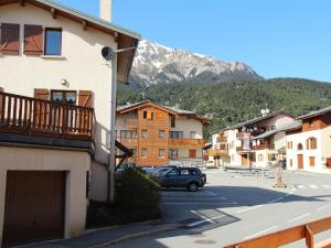 a car parked in a parking lot with a mountain at Appartement confortable 3/4 pers à Aussois - FR-1-508B-18 in Aussois +4 photos