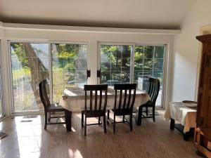 a dining room with a table and chairs and windows at Walnut in Owings Mills