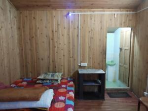 Zimmer mit einem Bett und einem Tisch sowie einem Bad in der Unterkunft EHI Homestay Rishop in Rishop