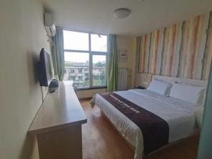 a hotel room with a bed and a television at 7 Days Inn Qingdao Haier Zone Ditie Tower Jiushui West Road in Qingdao +139 photos
