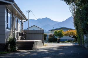 un portico di una casa con montagne sullo sfondo di Relaxing Kiwi Bach - Te Anau Holiday Home a Te Anau