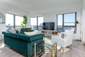 a living room with a green couch and white chairs at Central Balance Life Work Play in Cambridge