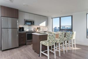 a kitchen with white cabinets and a counter with bar stools at Central Balance Life Work Play in Cambridge