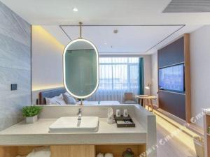 un baño con lavabo y espejo en GreenTree Inn Shandong Jinan Suncun New District Express Hotel, en Jinan