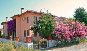 una casa con flores rosas delante de una valla en Villa Truva, en Fethiye