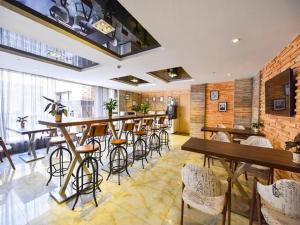 a bar in a restaurant with tables and stools at 7 Days Premium Shanghai Wild Animal Park Huinan in Shanghai