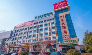 a large building with cars parked in front of it at GreenTree Inn Yancheng Dongtai Railway Station Beihai East Road Express Hotel in Xintuan