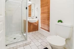 a bathroom with a toilet and a sink and a shower at Cabbage Palm Lodge - air conditioned home in town area in Agnes Water +17 photos
