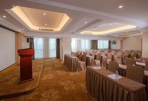 a large room with a podium in a room with chairs at Vienna Hotel Guangzhou Tianhe South China Botanical Garden Metro Station in Guangzhou