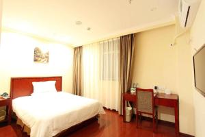 a hotel room with a bed and a desk and a bed and a chair at GreenTree Inn Nanjing Lishui District Lishui Airport Road Express Hotel in Lishui +137 photos