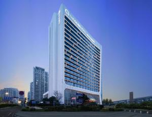 un alto edificio bianco con un cartello sopra di The QUBE Hotel Xiangyang a Xiangyang